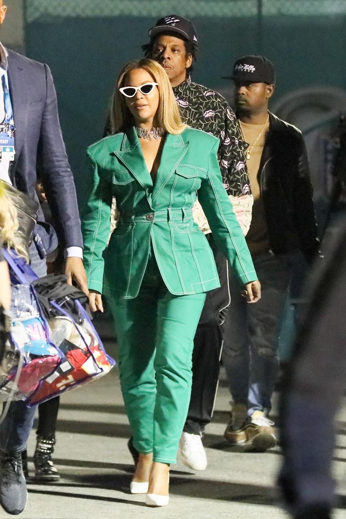 Beyonce w zielonym kombinezonie spaceruje z mężem. 