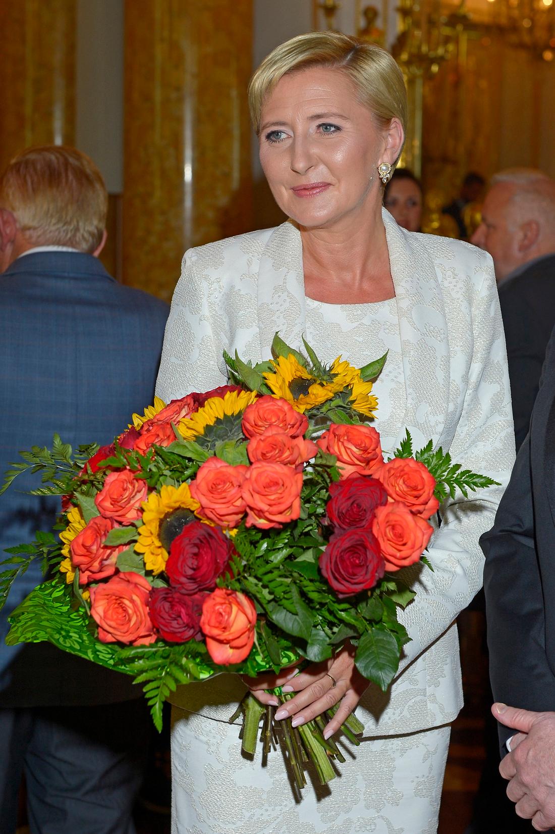 Agata Kornhauser-Duda pozuje z bukietem kwiatów. 