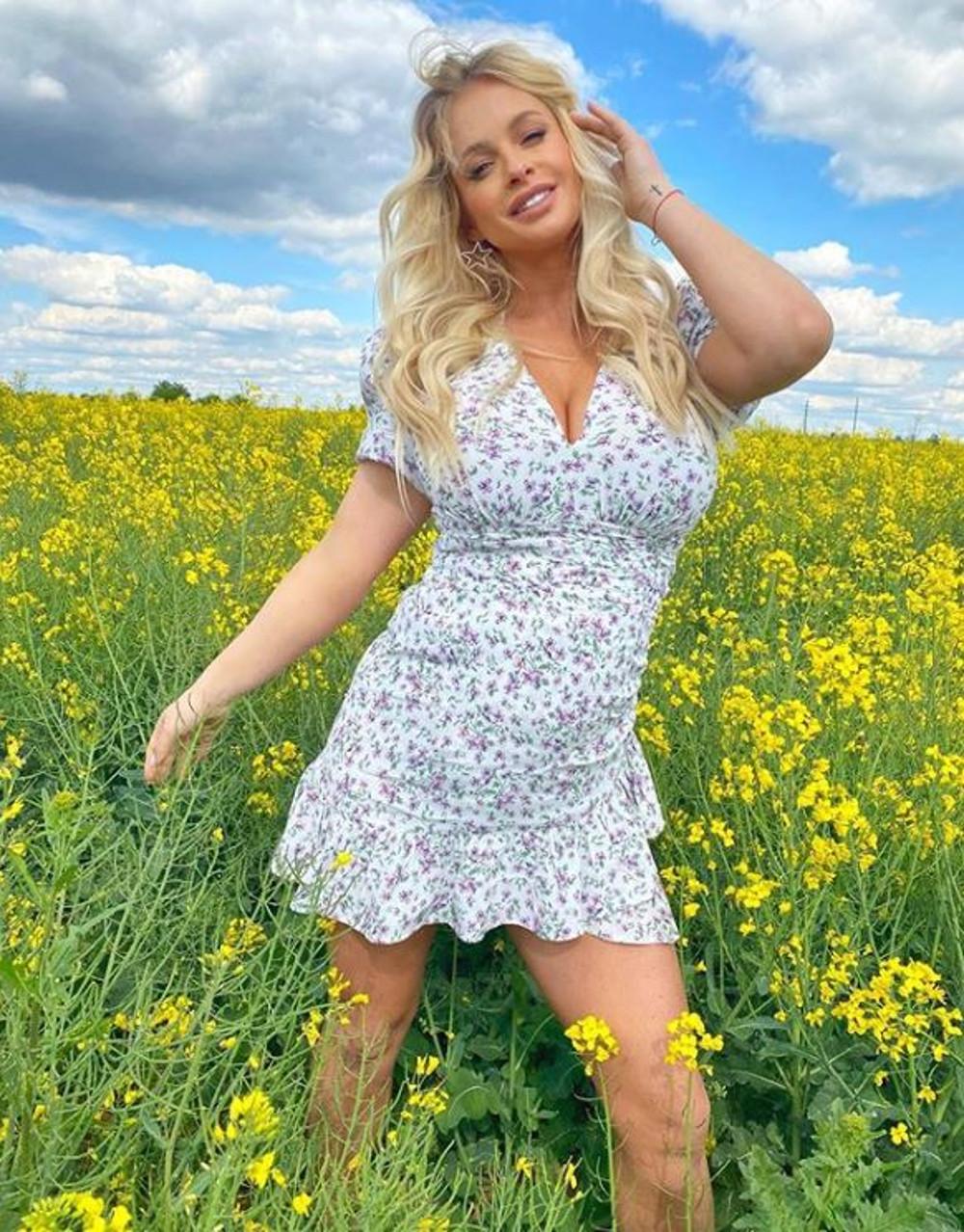 Paula Tumala w mini sukience pozuje w rzepaku. 