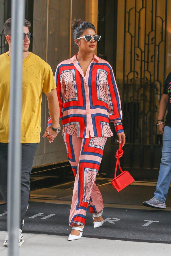 W kolorowym kostiumie z małą czerwoną torebką