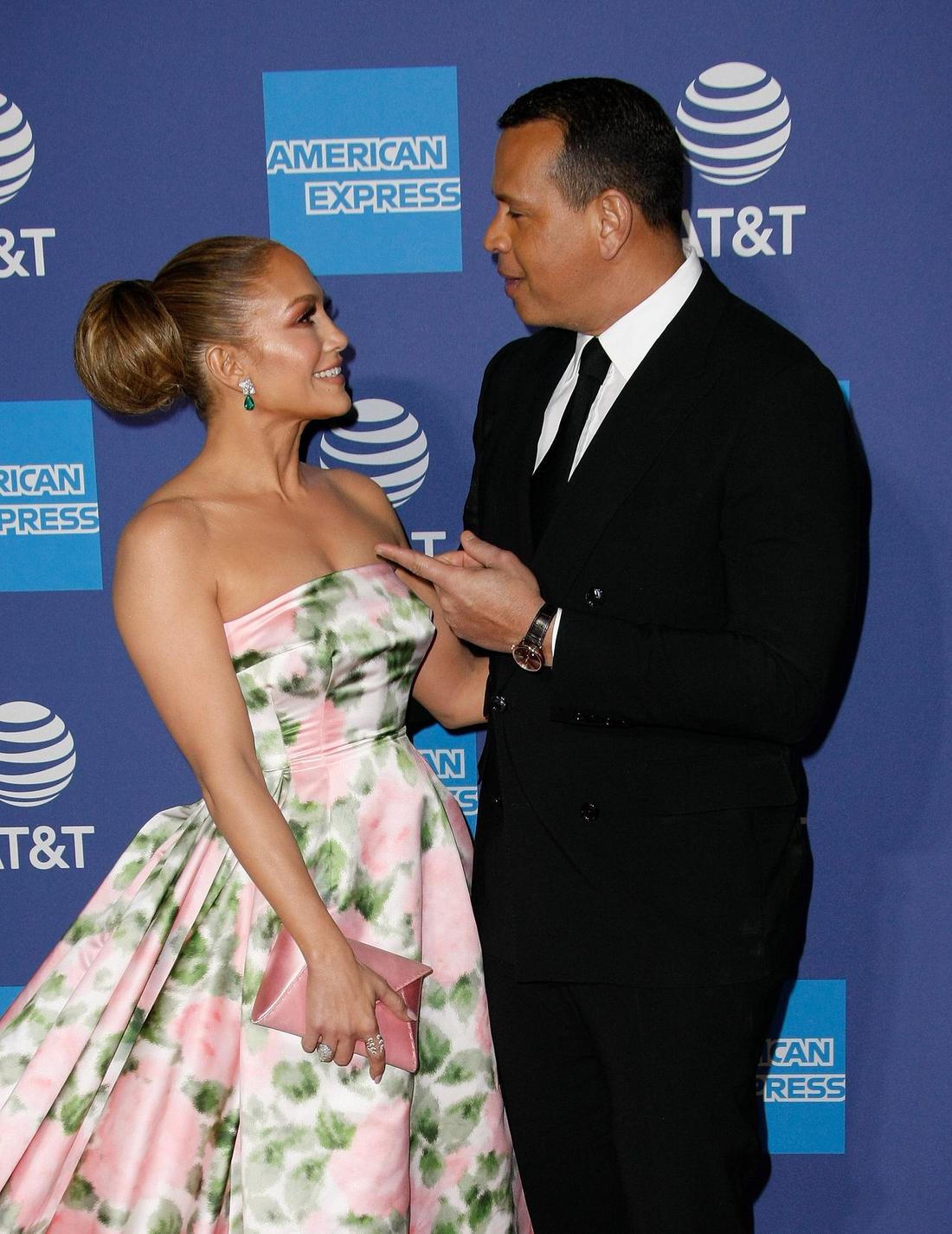 Jennifer Lopez w eleganckiej sukni z narzeczonym na ściance.