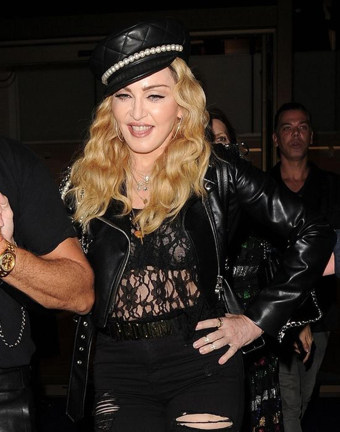 Madonna  w imprezowym nastroju uśmiecha się do fotoreporterów. 