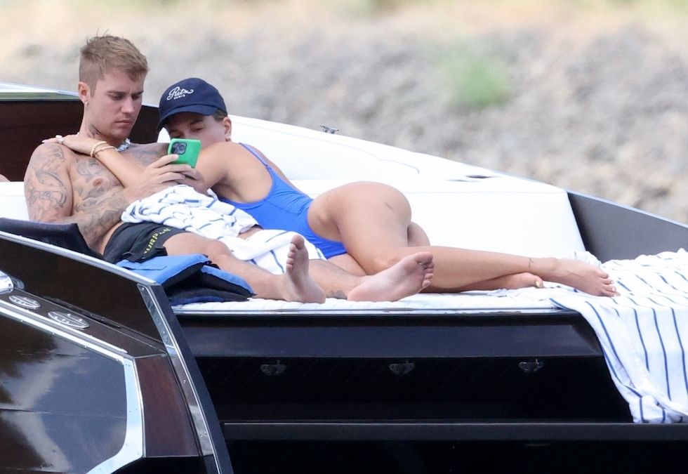 Couer d'Alene, ID - *PREMIUM-EXCLUSIVE* - As long as you love me. Justin and Hailey put on a very sweet loved up display as they lounge on a boat stern during ride on the lake in Couer d’Alene. Justin snuggled up to Hailey and the couple were seen enjoying a tender moment kissing and snuggling together. Justin who has been taking time off his tour after being diagnosed with Ramsey Hunt syndrome, a condition that occurs when a varicella-zoster virus infects a facial nerve. Symptoms include facial paralysis which Justin shared during a recent social media video shared with his followers. The singer wore black shorts and what appeared to be a necklace made of shells or large beads around his neck and was seen going for a swim in the lake. Hailey meanwhile sported a cheeky cobalt one piece and a cap from Ritz Paris to protect from the sun. The couple have been vacationing in the scenic are a of northwest Idaho known for it’s water sports and beautiful trails. BACKGRID USA 11 JULY 2022,Image: 706673968, License: Rights-managed, Restrictions: , Model Release: no, Pictured: Justin Bieber, Hailey Bieber, Credit line: Splash News / BACKGRID / Backgrid USA / Forum
