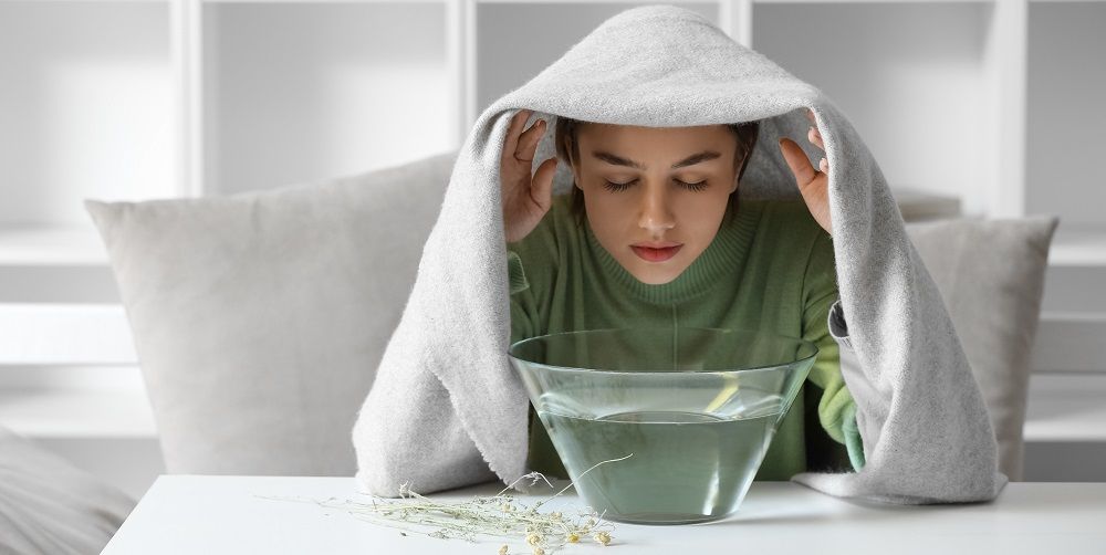 Young woman doing steam inhalation at home to soothe and open nasal passages