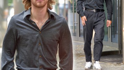 Maciej Musiał w dłuższych włosach i z kolczykiem w uchu pod studiem “Dzień Dobry TVN”