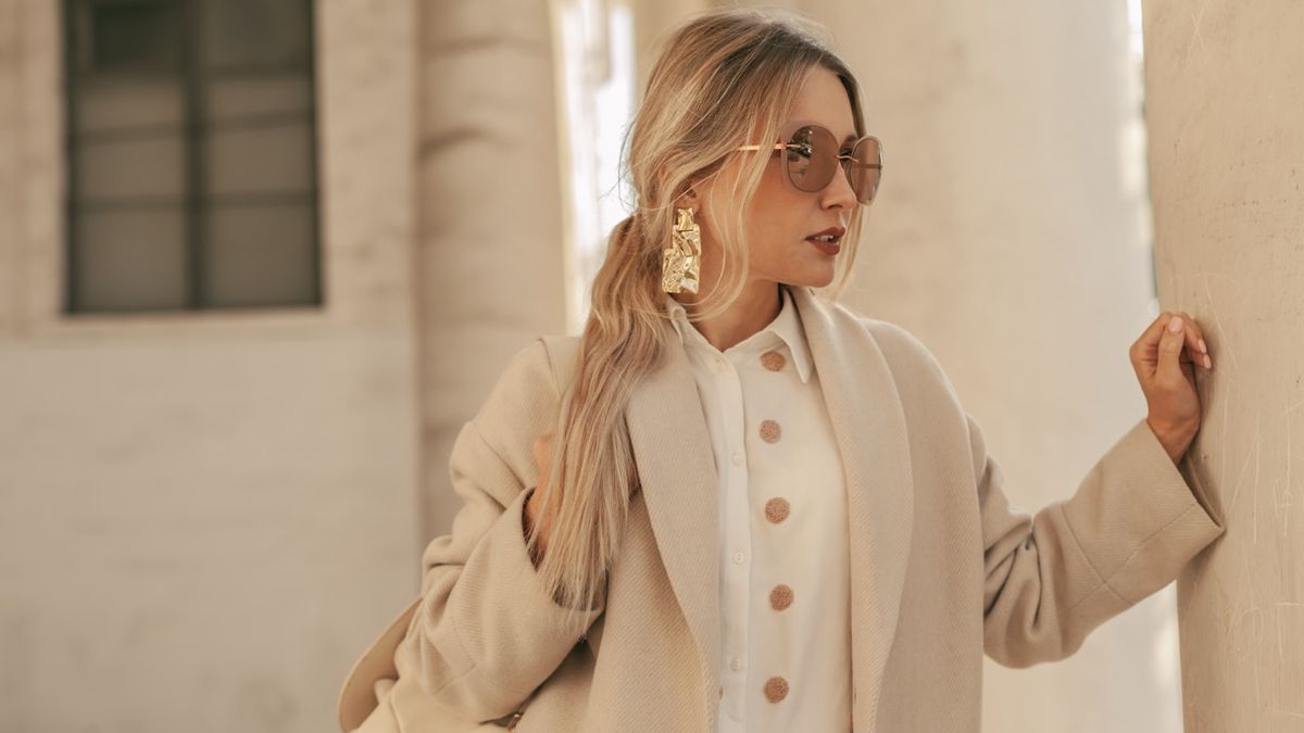 Fashion woman wearing beige trendy coat walking on the street