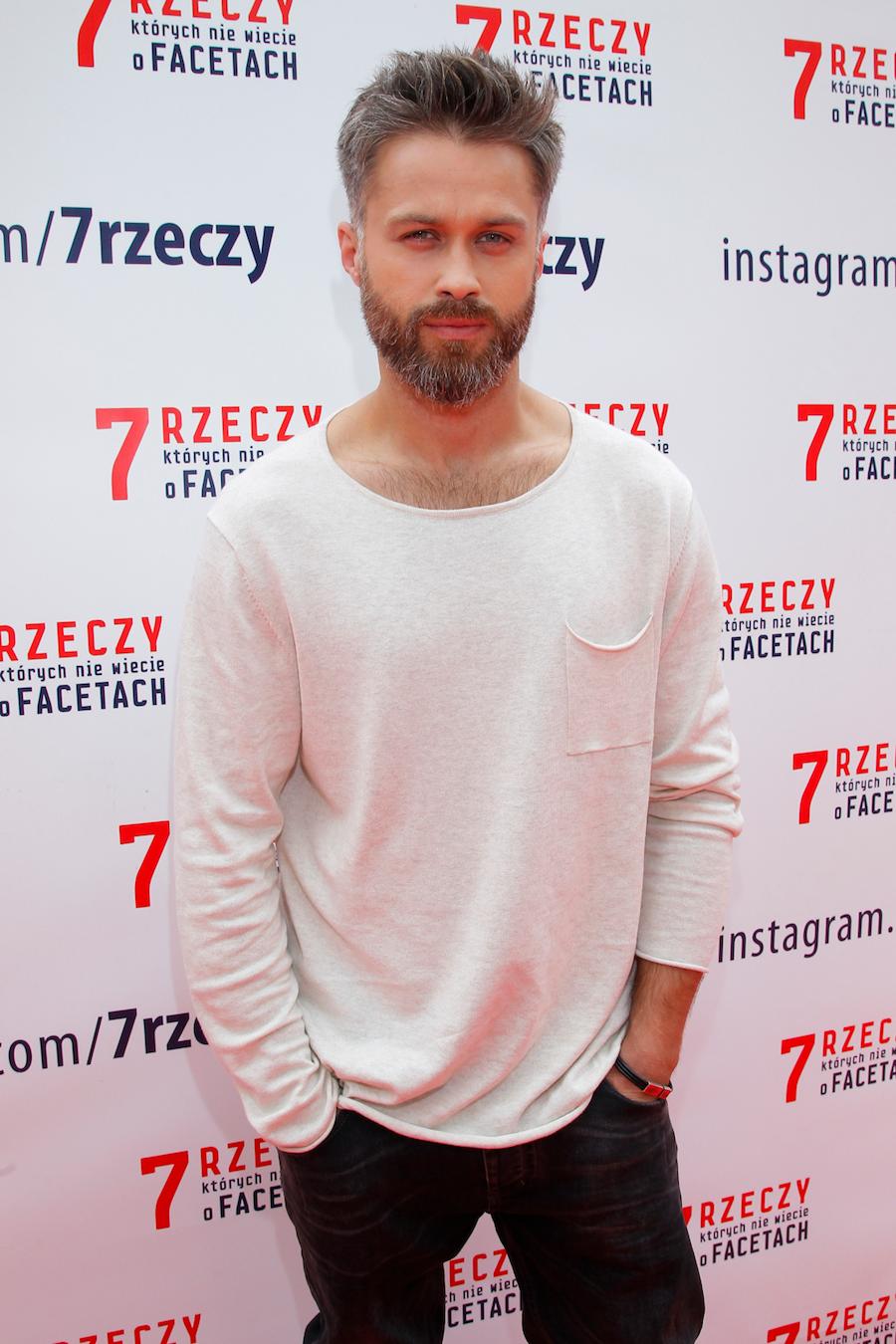 Brodaty Maciej Zakościelny na ściance. 