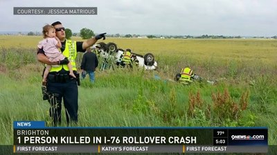 Policjant trzyma dziecko, którego ojciec zginął w wypadku