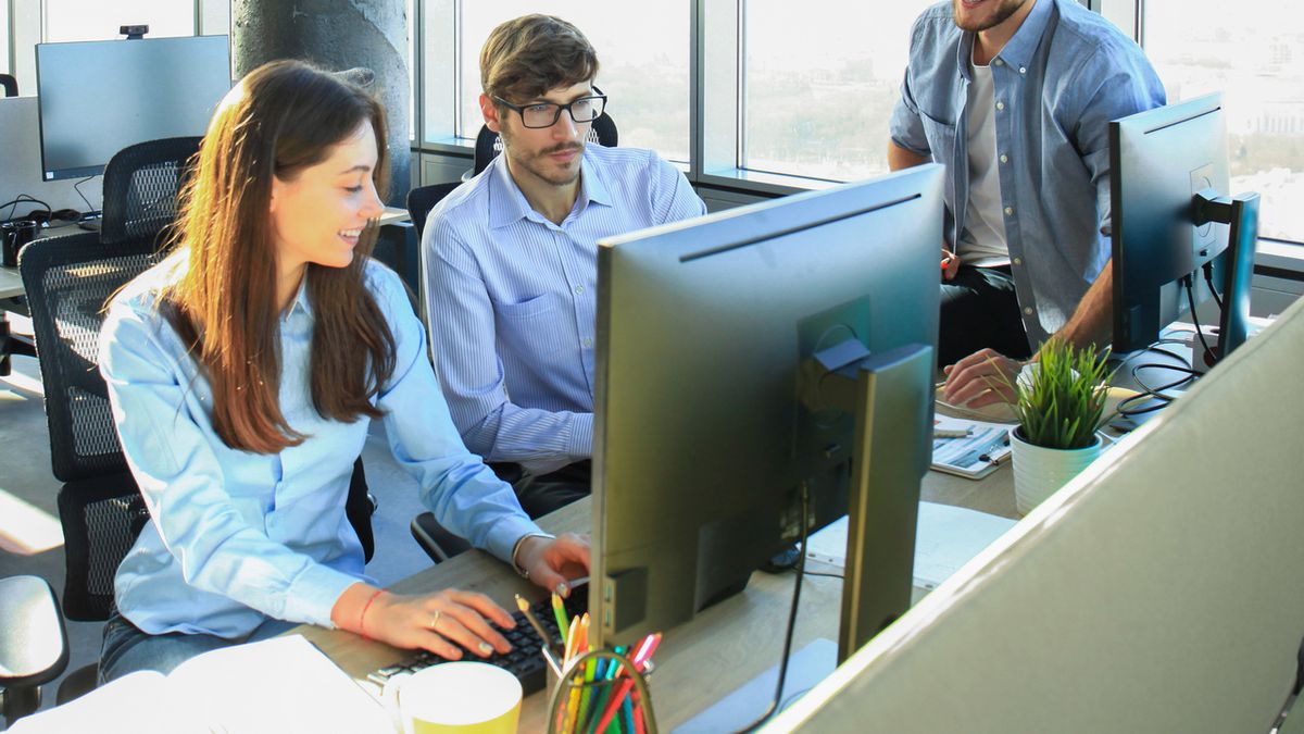 Young colleagues in smart casual wear working while spending time in the office